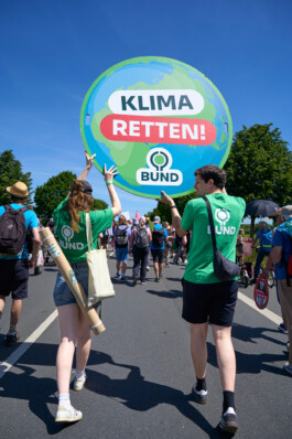 BUND-Aktivist:innen tragen ein schild "Klima Retten" über eine Demonstration.