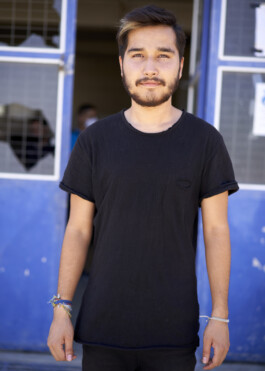 Refugee Camp Moria, Lesbos Lesvos Griechenland Anne Barth, Junger Mann vor einem Gebäude mit zerbrochenen Scheiben
