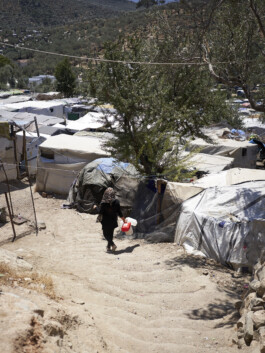 Refugee Camp Moria, Lesbos Lesvos Griechenland Anne Barth, eine Frau trägt leere Kanister auf einem Trampelpfad durch das Lager